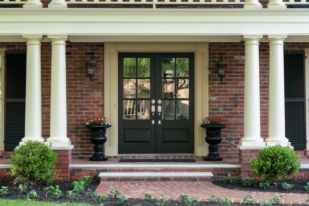 Cette image montre un porche d'entrée de maison avant traditionnel avec des pavés en brique.
