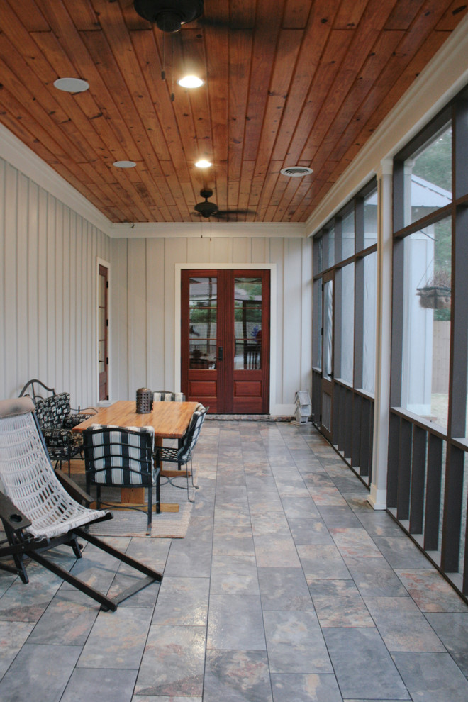 Inspiration pour un porche d'entrée de maison arrière craftsman de taille moyenne avec une moustiquaire, du carrelage et une extension de toiture.