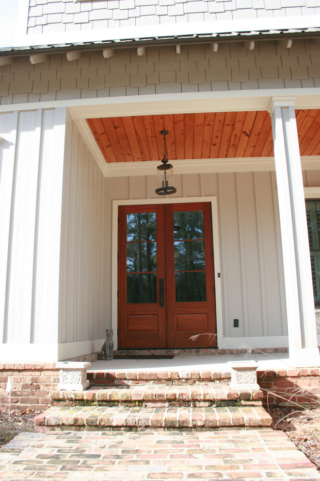 Esempio di un portico stile americano di medie dimensioni e davanti casa con lastre di cemento e un tetto a sbalzo
