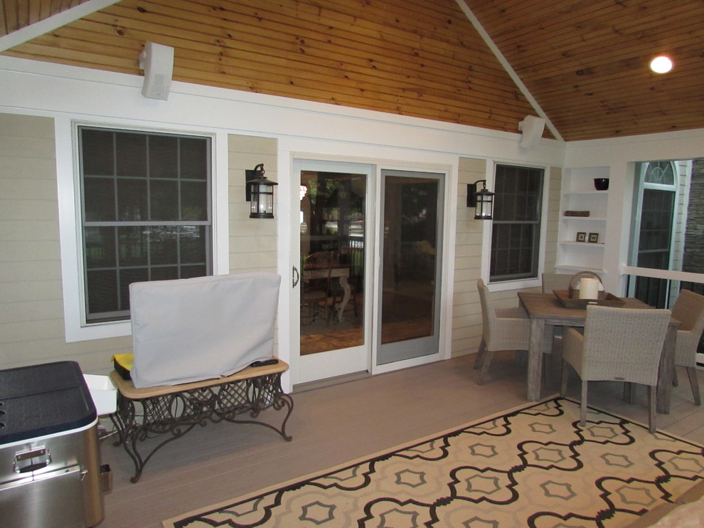 Cette image montre un porche d'entrée de maison arrière traditionnel de taille moyenne avec une moustiquaire et une extension de toiture.