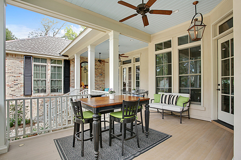 This is an example of a large craftsman side porch design in New Orleans with a roof extension and decking.