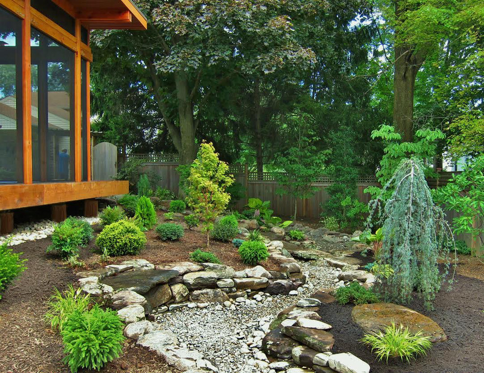 Aménagement d'un petit jardin arrière asiatique avec des pavés en pierre naturelle.