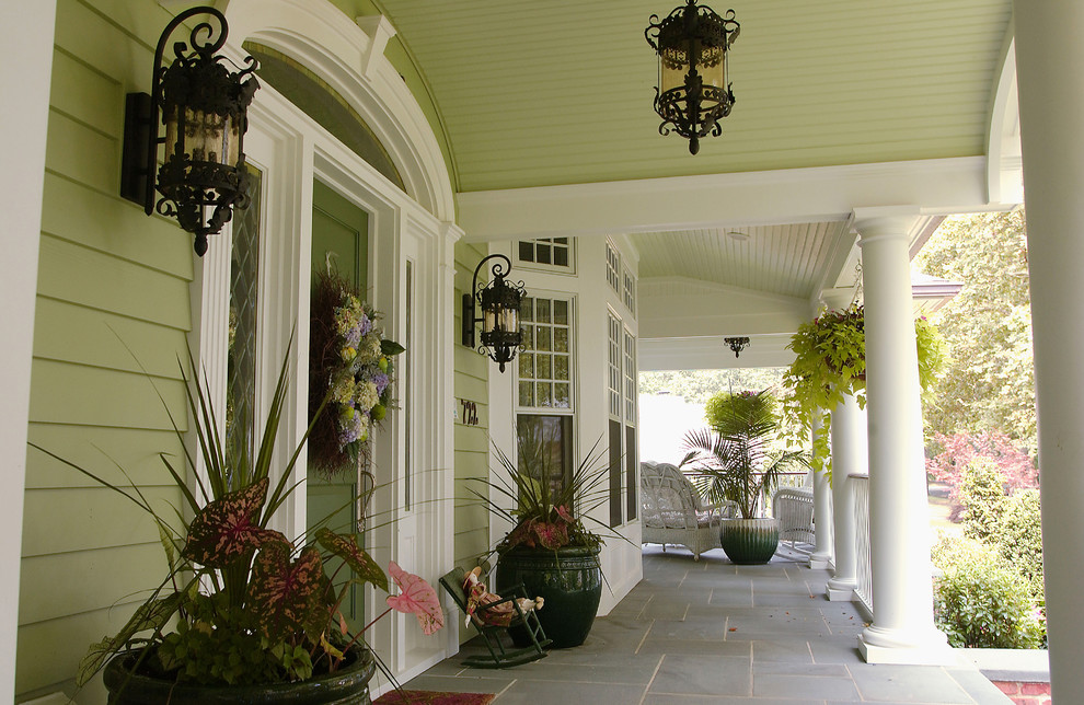 Aménagement d'un grand porche d'entrée de maison avant classique avec des pavés en béton et une extension de toiture.