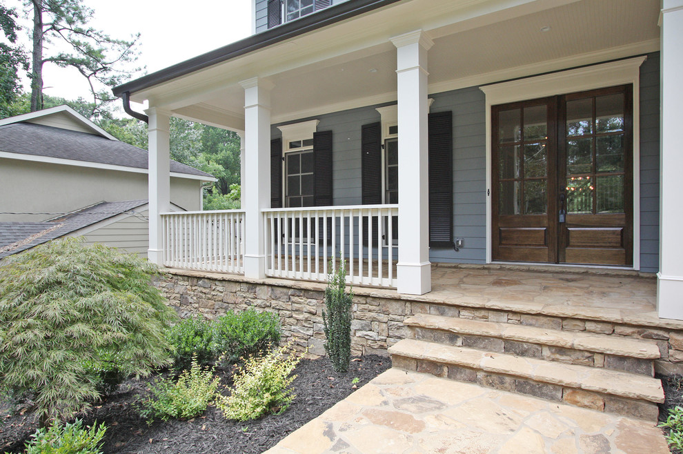 Inspiration for a mid-sized timeless stone front porch remodel in Atlanta with a roof extension