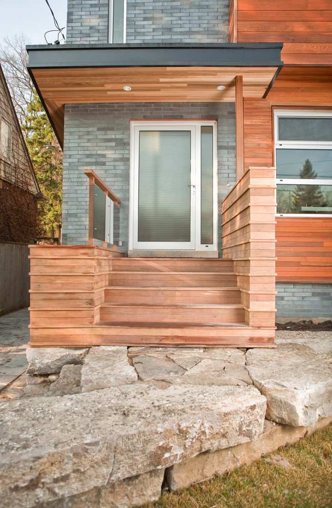 Réalisation d'un petit porche d'entrée de maison avant minimaliste avec une terrasse en bois.