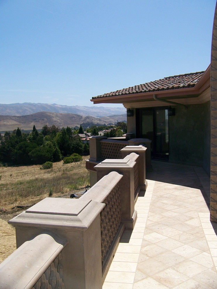 Foto på en stor medelhavsstil veranda på baksidan av huset, med marksten i tegel och takförlängning