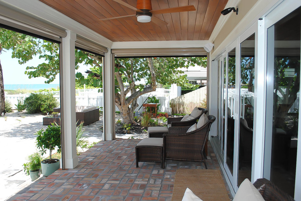 Mid-sized classic brick back porch idea in Tampa with a roof extension