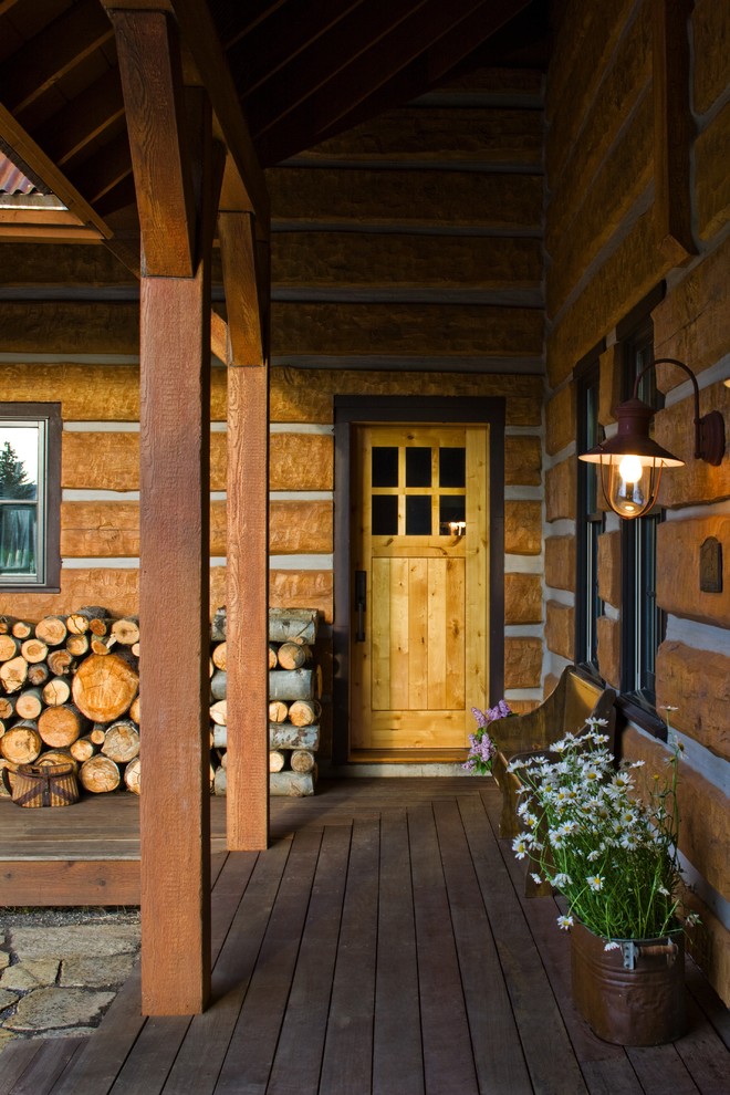 Idée de décoration pour un porche d'entrée de maison chalet avec une terrasse en bois et une extension de toiture.