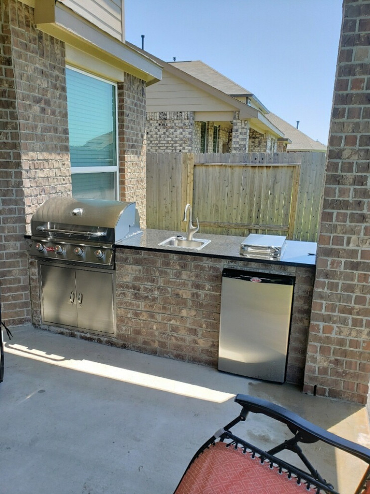 Mittelgroße, Überdachte Klassische Veranda hinter dem Haus mit Outdoor-Küche und Betonplatten in Dallas