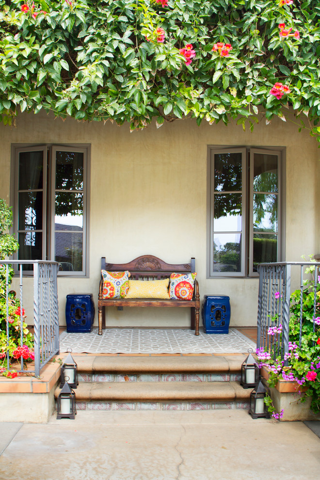 Ejemplo de terraza mediterránea en patio delantero con suelo de baldosas y pérgola