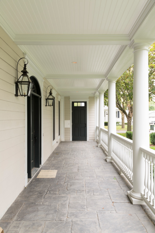 Immagine di un portico classico di medie dimensioni e davanti casa con pavimentazioni in pietra naturale e un tetto a sbalzo