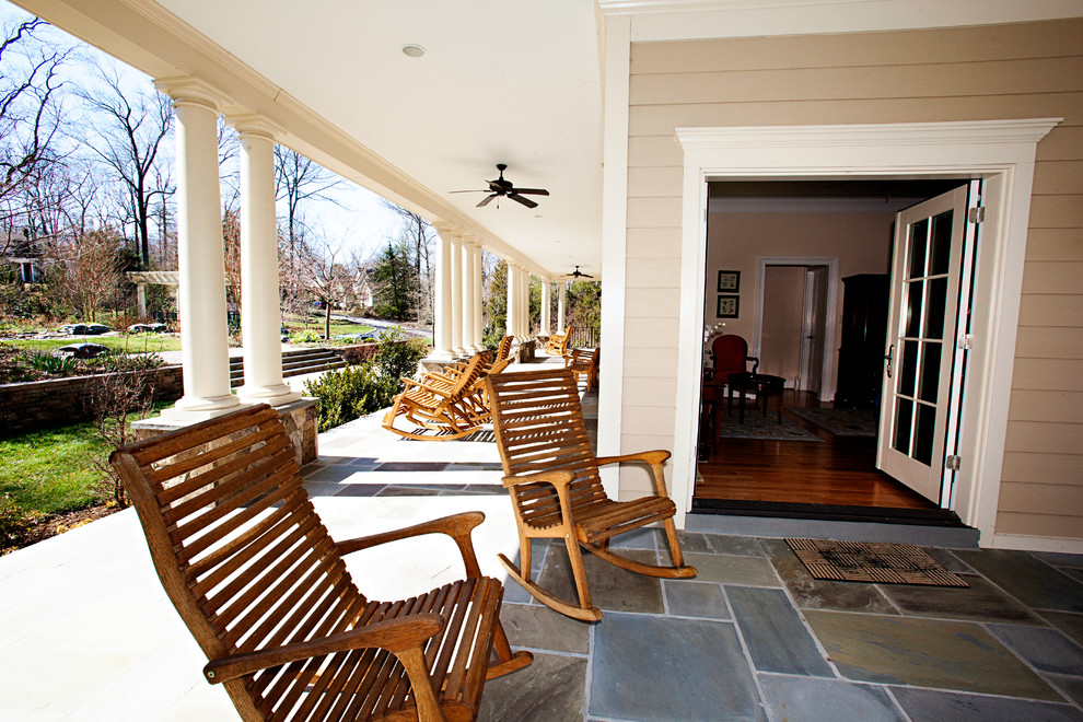 Ejemplo de terraza clásica extra grande en patio delantero con adoquines de piedra natural y toldo