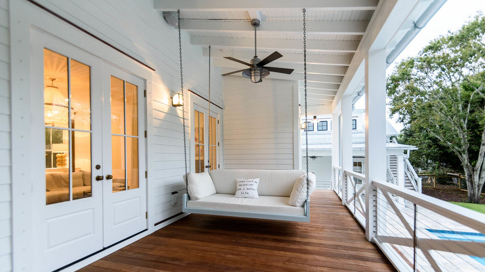 This is an example of a large nautical front veranda in Charleston with decking.