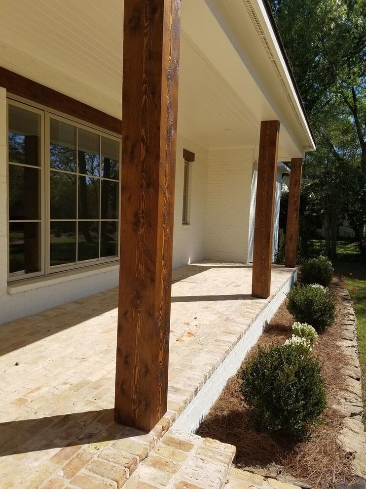 Idéer för en mellanstor lantlig veranda framför huset, med marksten i tegel och takförlängning