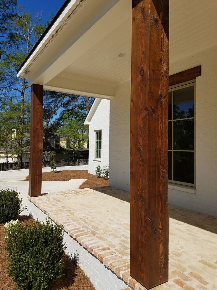 Idee per un portico country di medie dimensioni e davanti casa con pavimentazioni in mattoni e un tetto a sbalzo