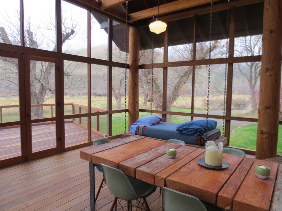 Cette image montre un porche d'entrée de maison latéral chalet de taille moyenne avec une moustiquaire et une terrasse en bois.
