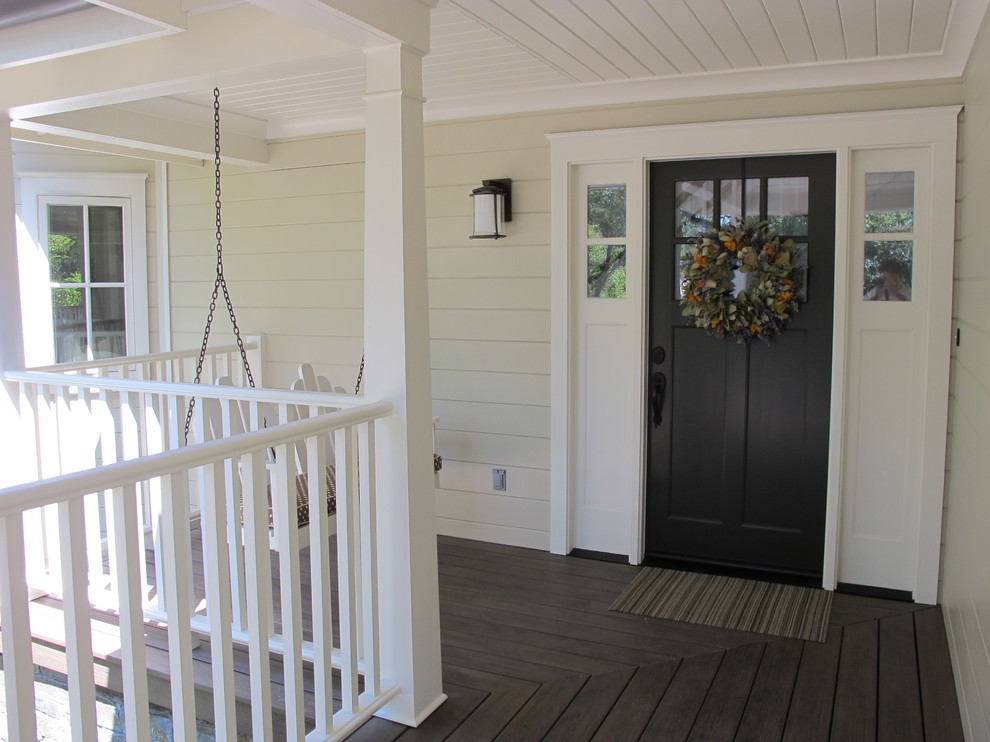 Aménagement d'un porche d'entrée de maison campagne avec une terrasse en bois.