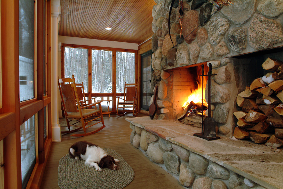 Design ideas for a rustic veranda in Grand Rapids with a fire feature and a roof extension.