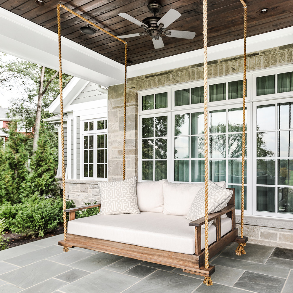 Classic stone front porch idea in Chicago with a roof extension