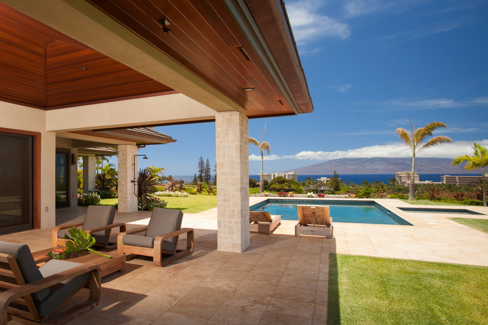 Large trendy stone back porch photo in Hawaii with a roof extension