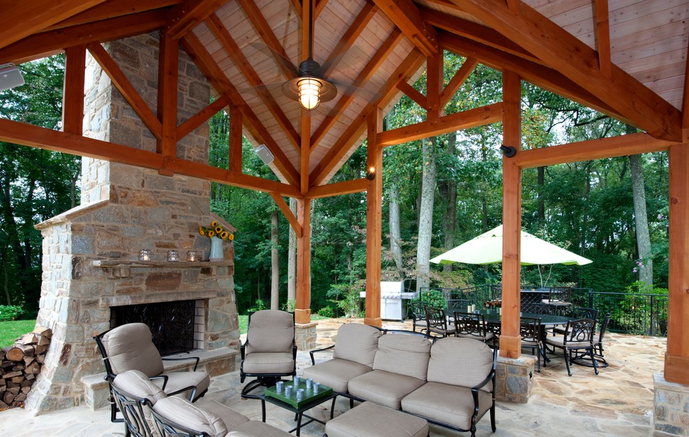 Idee per un grande portico stile rurale dietro casa con un caminetto, pavimentazioni in pietra naturale e un tetto a sbalzo