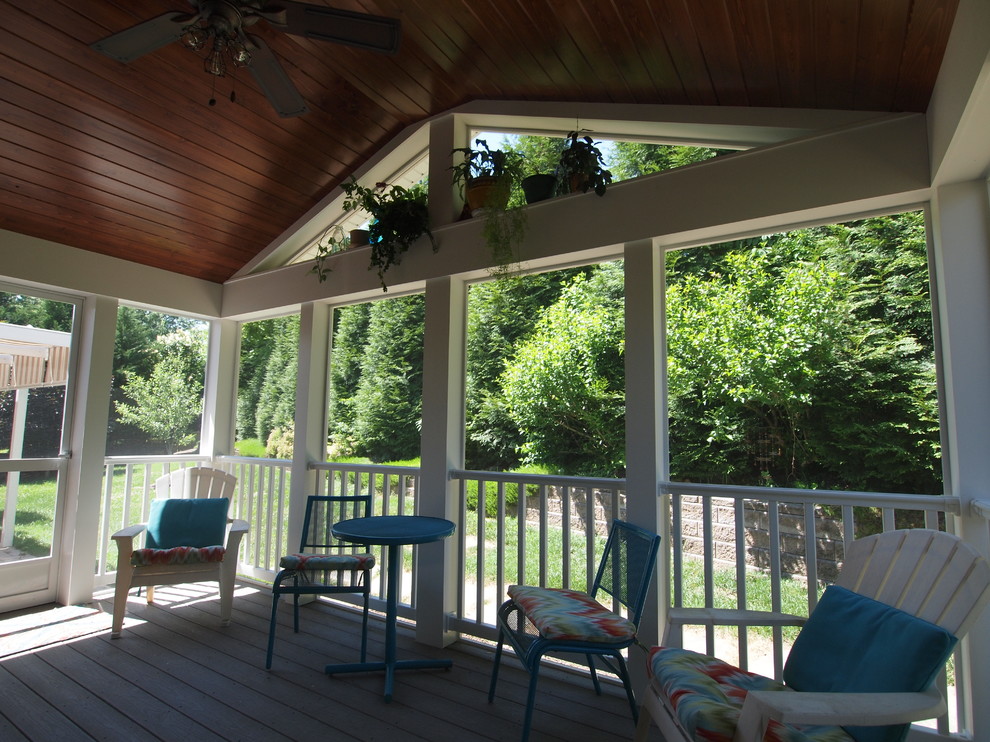 Aménagement d'un petit porche d'entrée de maison arrière classique avec une terrasse en bois et une extension de toiture.