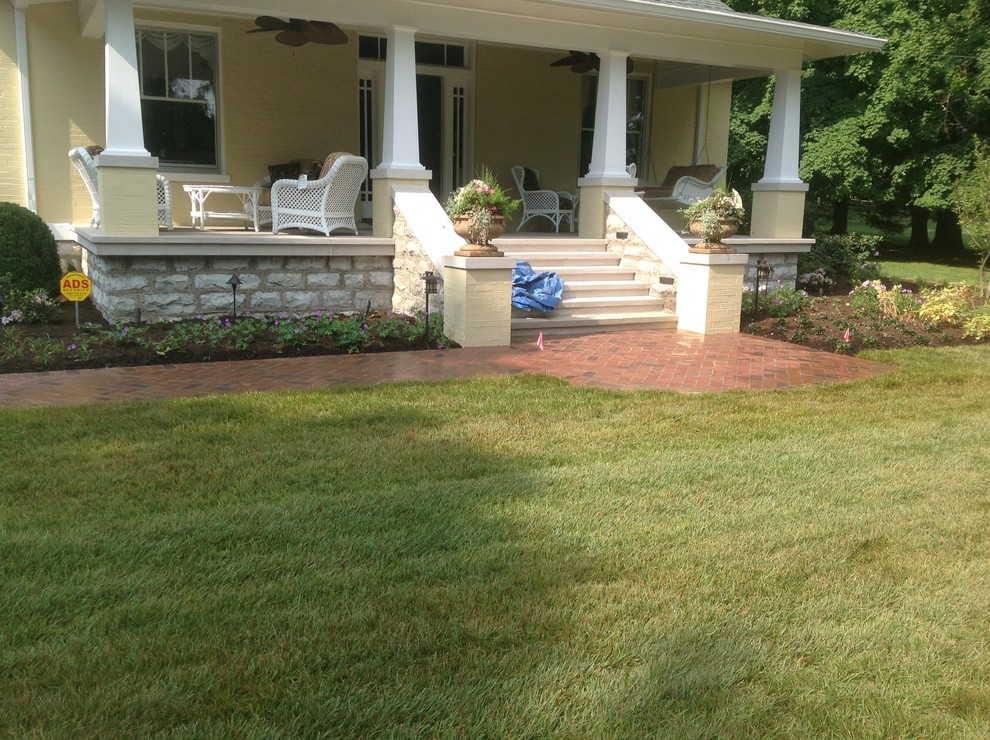 Mid-sized elegant brick front porch photo in Nashville with a roof extension