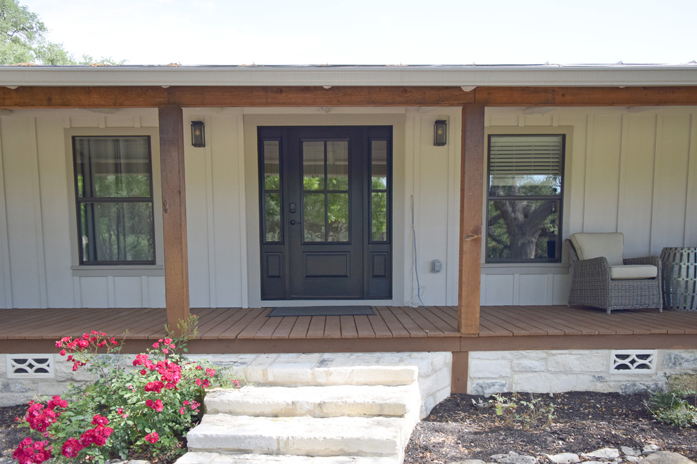 Large farmhouse concrete paver front porch photo in Austin with a roof extension