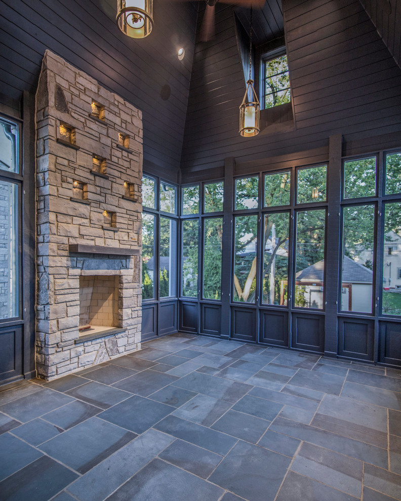 Huge transitional stone screened-in back porch idea in Chicago with a roof extension