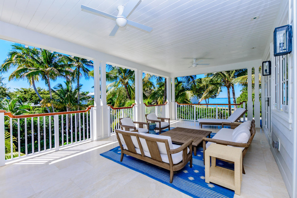 This is an example of a large side veranda in Miami with tiled flooring and a roof extension.