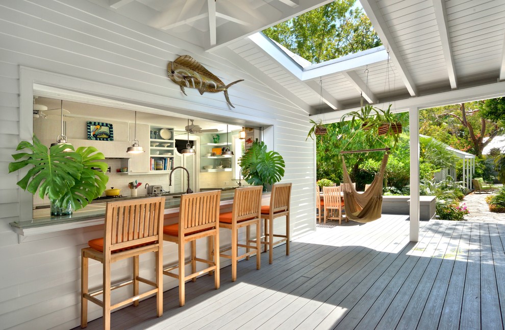 Cette photo montre un porche d'entrée de maison chic de taille moyenne avec une terrasse en bois et une extension de toiture.