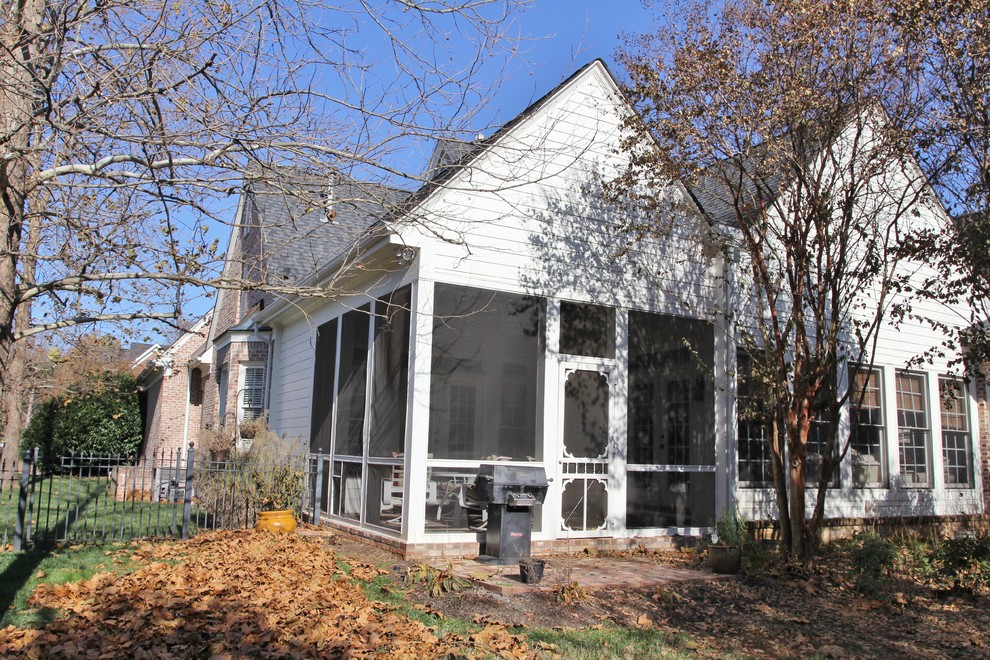 Foto di un portico chic di medie dimensioni e dietro casa con un portico chiuso, pavimentazioni in mattoni e un tetto a sbalzo