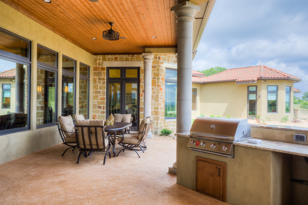 Überdachte Mediterrane Veranda hinter dem Haus mit Outdoor-Küche und Betonplatten in Austin