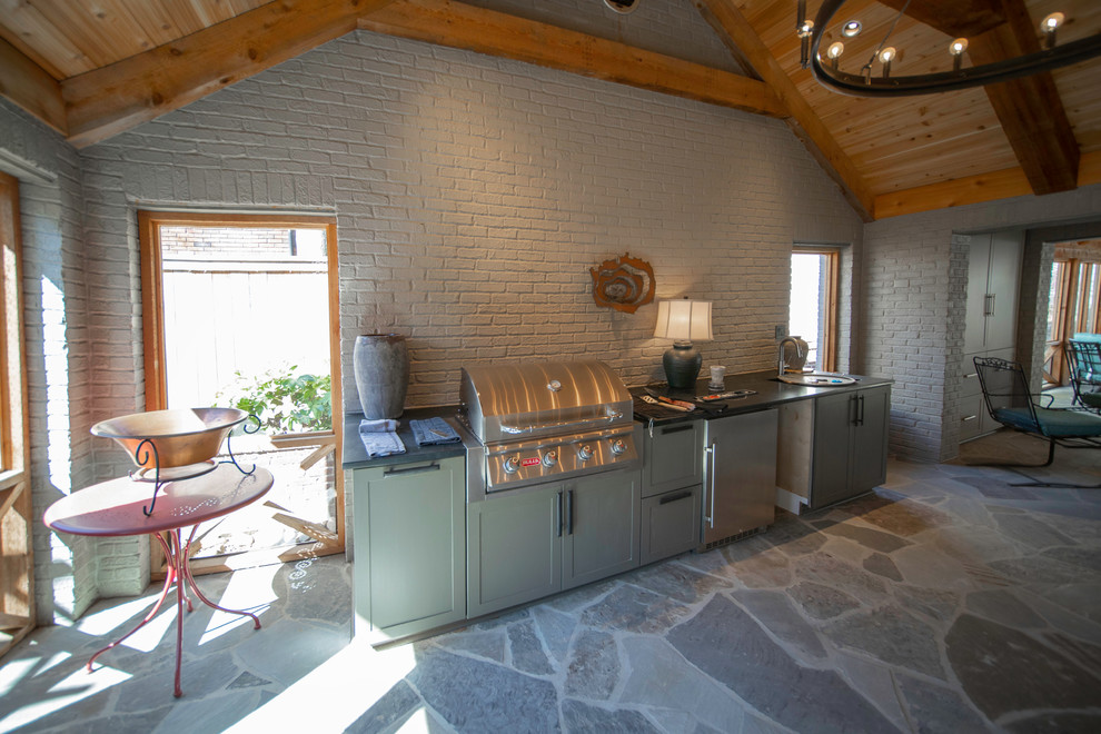 Exemple d'un grand porche d'entrée de maison arrière craftsman avec une cheminée, des pavés en pierre naturelle et une extension de toiture.