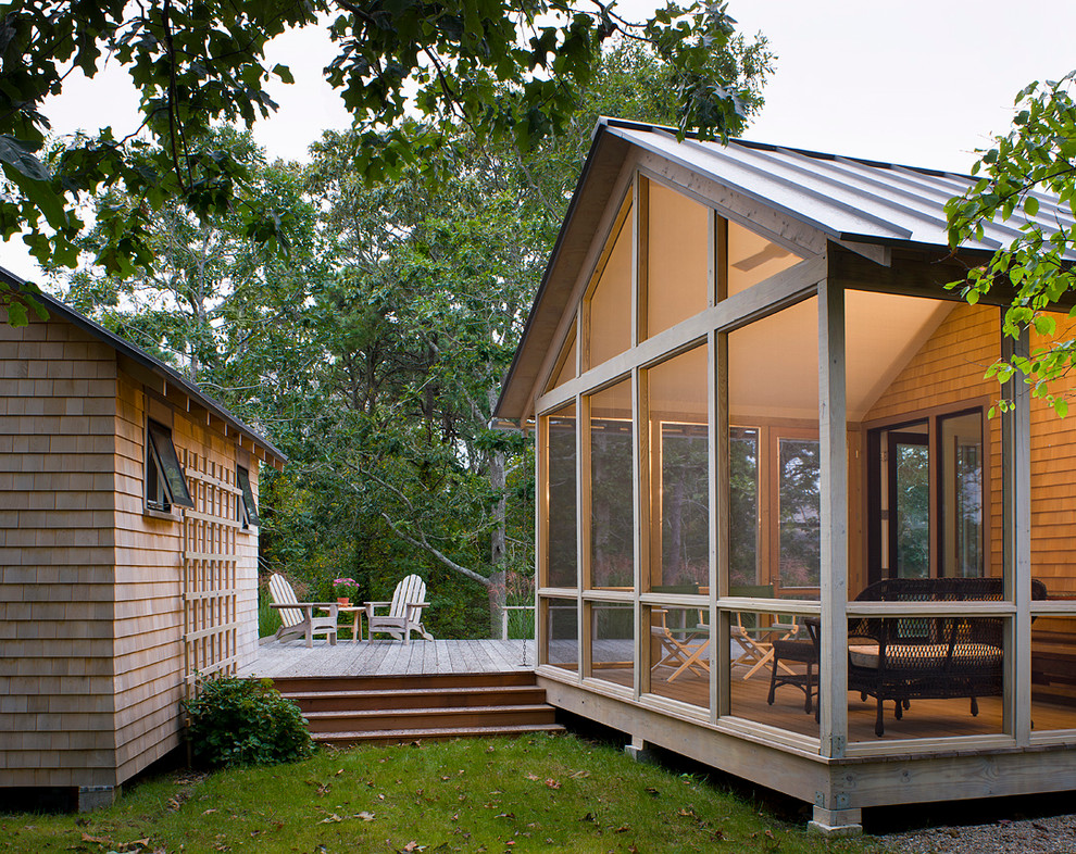 Cette photo montre un porche d'entrée de maison nature avec une terrasse en bois, une extension de toiture et une moustiquaire.