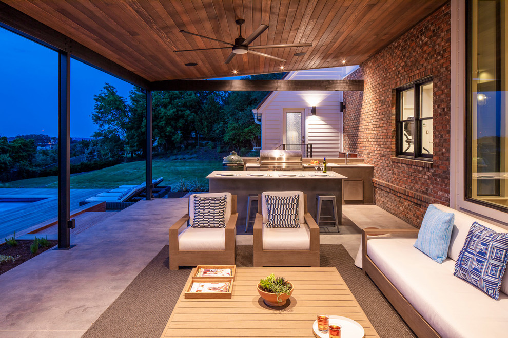 Inspiration for a large contemporary concrete porch remodel in Austin with an awning