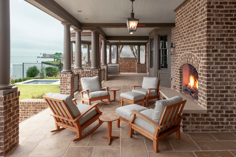 This is an example of a traditional tile back porch design in Houston with a roof extension.
