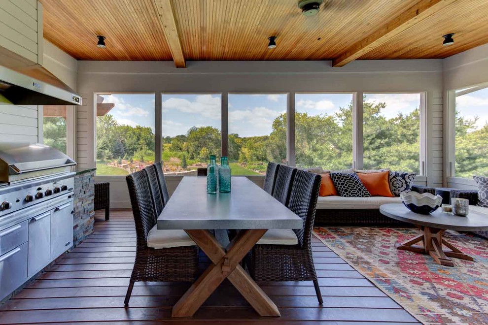 Cette image montre un grand porche d'entrée de maison arrière design avec une moustiquaire, une terrasse en bois et une extension de toiture.