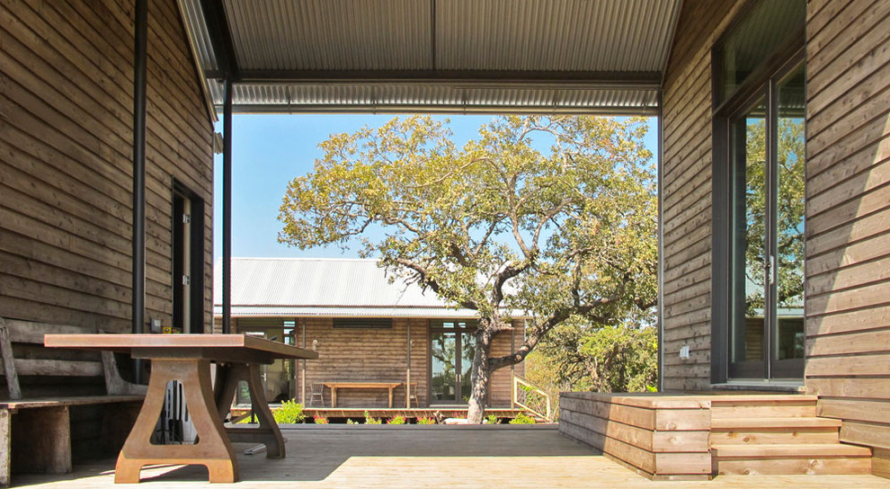 Rustic veranda in Austin with a roof extension.