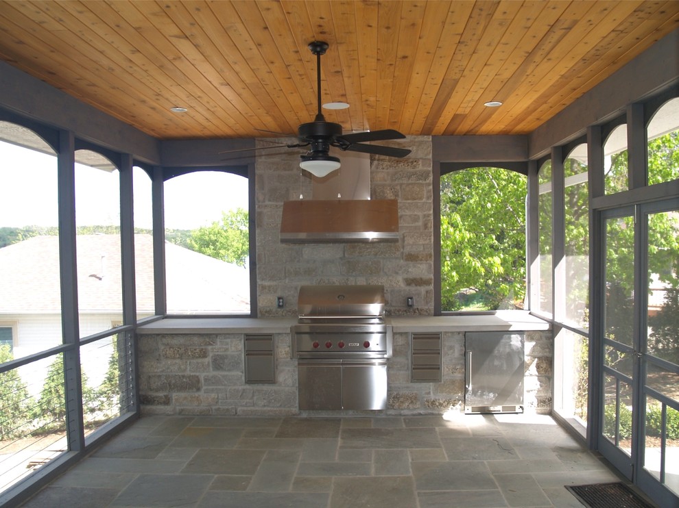 Design ideas for a large contemporary side veranda in Milwaukee with an outdoor kitchen, natural stone paving and a roof extension.