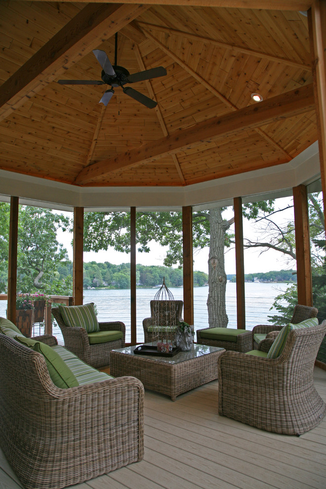 Réalisation d'un porche d'entrée de maison arrière tradition de taille moyenne avec une moustiquaire, une terrasse en bois et une extension de toiture.