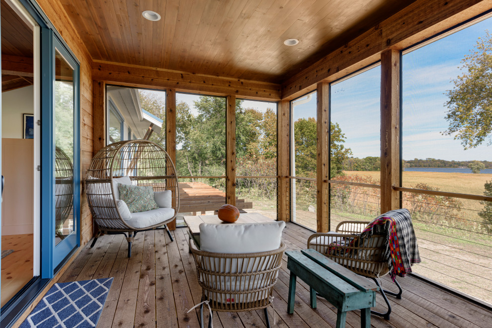 Aménagement d'un grand porche d'entrée de maison arrière campagne avec une moustiquaire, des pavés en pierre naturelle et une extension de toiture.