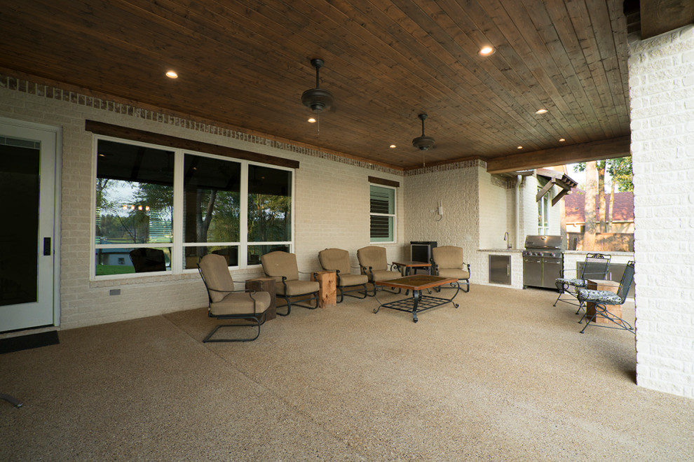 Inspiration for a large craftsman concrete porch remodel in Dallas with a roof extension