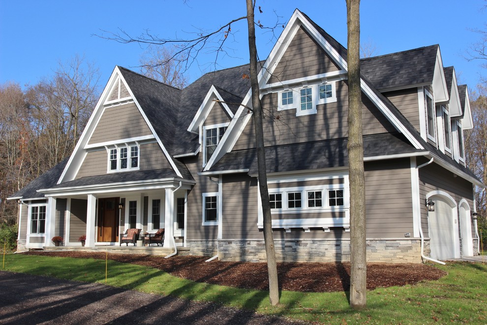 Cette image montre un porche d'entrée de maison avant craftsman de taille moyenne avec une dalle de béton et une extension de toiture.