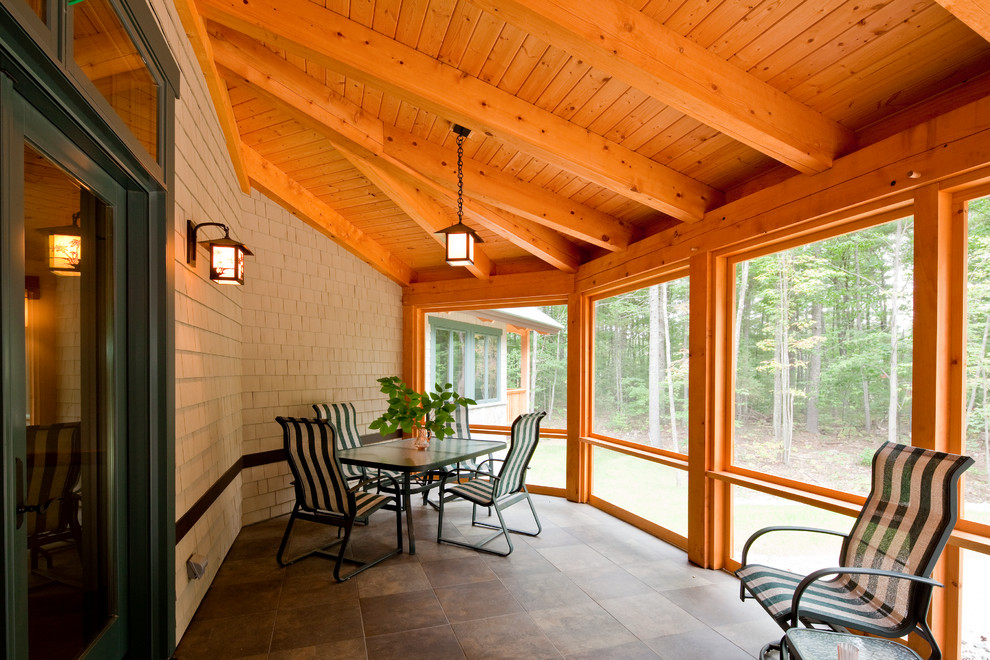 Exemple d'un grand porche d'entrée de maison montagne avec du carrelage et une extension de toiture.