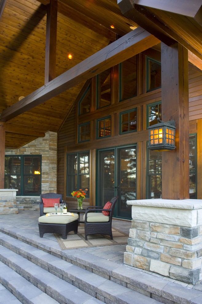 Inspiration pour un porche d'entrée de maison chalet avec des pavés en béton et une extension de toiture.
