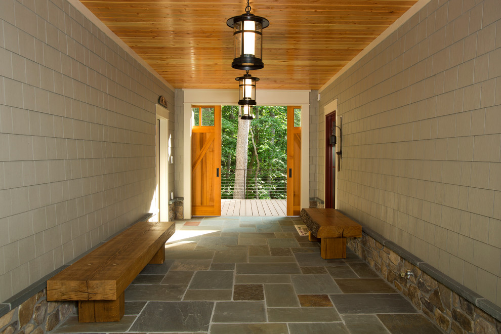 Mountain style stone porch idea in DC Metro with a roof extension