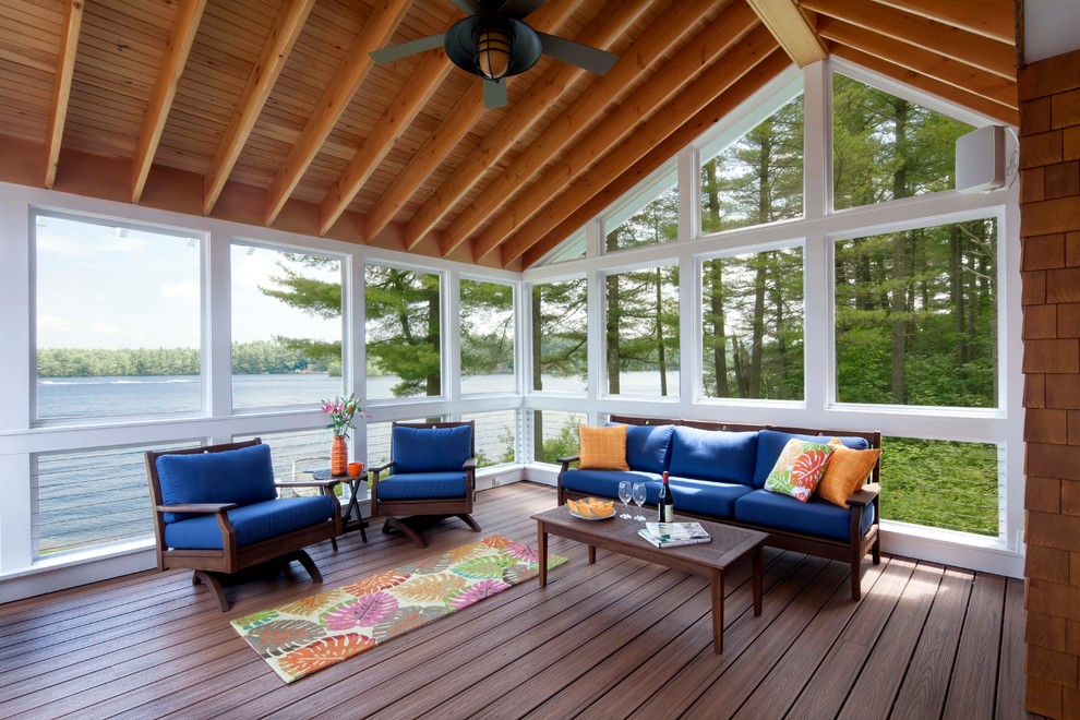 Idée de décoration pour un porche d'entrée de maison arrière marin avec une moustiquaire, une extension de toiture et une terrasse en bois.
