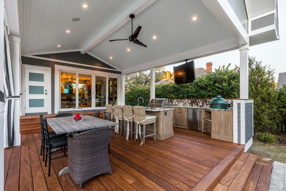 Cette image montre un grand porche d'entrée de maison arrière traditionnel avec une cuisine d'été, des pavés en béton et une extension de toiture.
