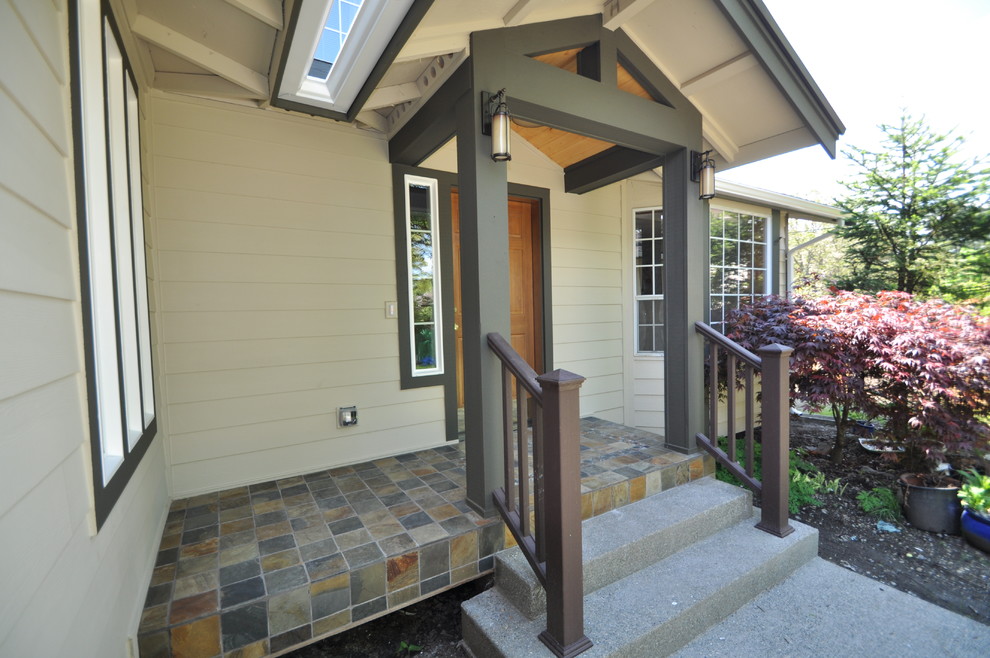 Idee per un piccolo portico american style davanti casa con lastre di cemento